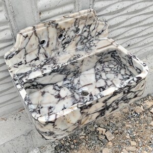 Designer marble sink made from Calacatta Viola stone with a matching backsplash, perfect for elegant bathroom spaces.