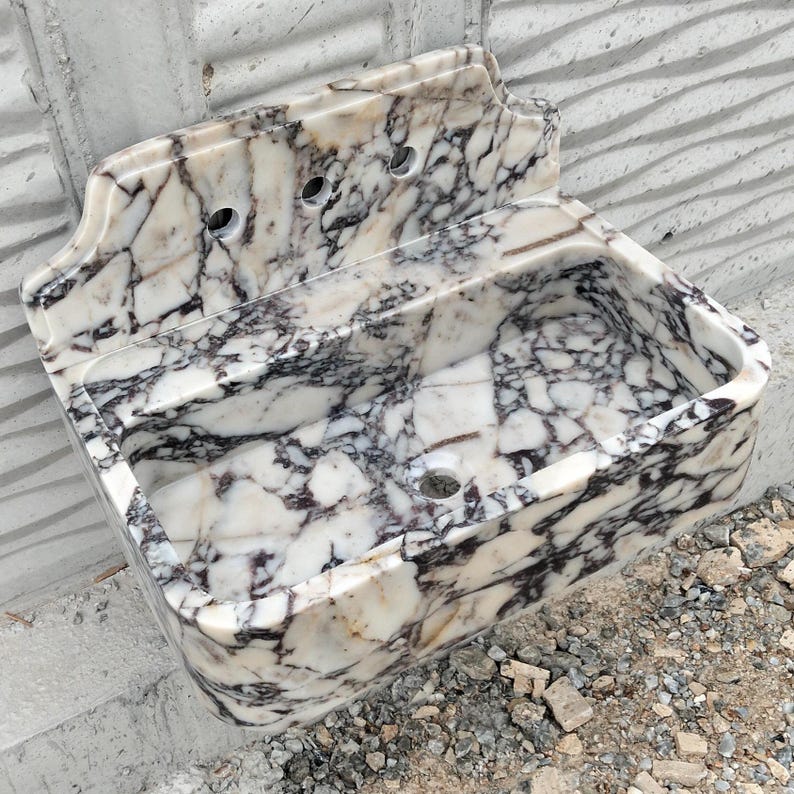 Designer marble sink made from Calacatta Viola stone with a matching backsplash, perfect for elegant bathroom spaces.