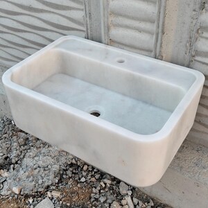 A beautifully crafted Carrara marble sink paired with a matching backsplash for added elegance.