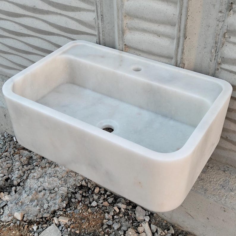 A beautifully crafted Carrara marble sink paired with a matching backsplash for added elegance.