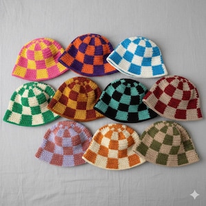 Peut inclure: Collection de dix chapeaux seau crochetés à la main. Chaque chapeau présente un motif de damier dans diverses couleurs, notamment rose et jaune, violet et orange, bleu et blanc, vert et blanc, marron et jaune, noir et sarcelle, et rouge et beige.