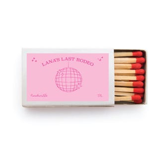 May include: A matchbox with a pink label featuring the text "LANA'S LAST RODEO" and a disco ball graphic. The word "Nashville" is printed below. The matches have red tips.
