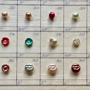 May include: A collection of various buttons in different colors and shapes, arranged in a grid. The buttons include round, flower, and swirl designs, with sizes ranging from 4 to 6 inches.
