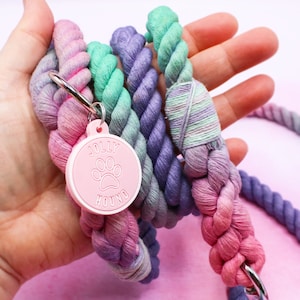 May include: A multi-colored rope dog leash with a pink tag that says "Jolly Hound" and a paw print.
