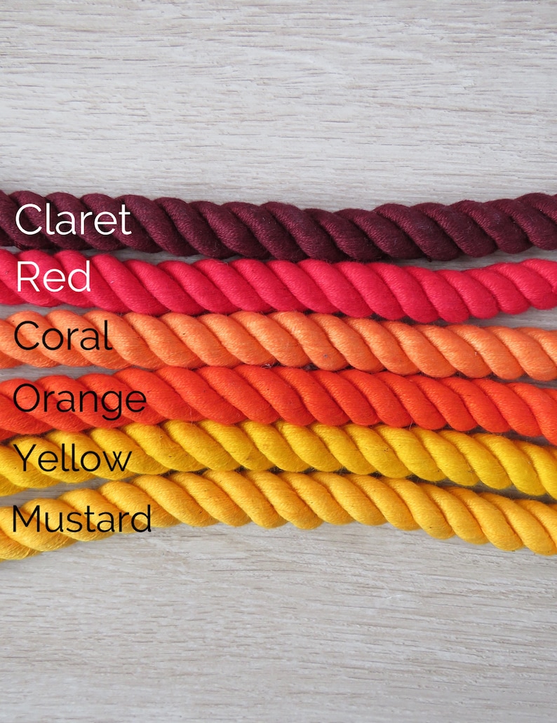 Pode incluir: Seis rolos de corda de algod&atilde;o em v&aacute;rios tons de vermelho, laranja e amarelo. As cores s&atilde;o, de cima para baixo, vinho tinto, vermelho, coral, laranja, amarelo e mostarda.