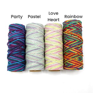 May include: Four spools of colorful thread are displayed against a white background. The spools are labeled "Party," "Pastel," "Love Heart," and "Rainbow." Each spool is tightly wound with various colors, including blue, purple, yellow, and red.