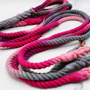 May include: Two pink and gray ombre rope dog leashes with gold metal hardware.