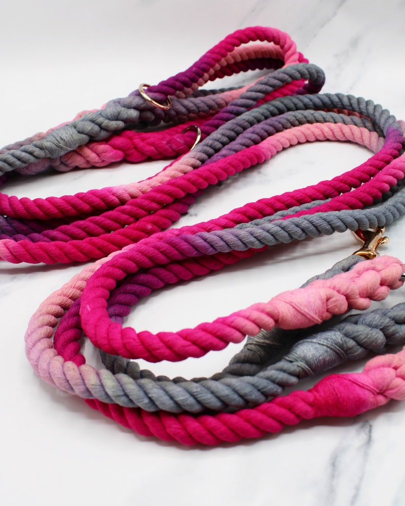 May include: Two pink and gray ombre rope dog leashes with gold metal hardware.