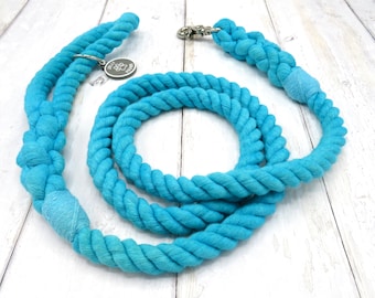 May include: A blue cotton rope dog leash with a silver clip and a silver charm with a paw print.