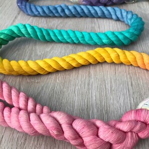 May include: A set of four colorful cotton rope leashes in rainbow colors, including purple, blue, green, yellow, and pink.