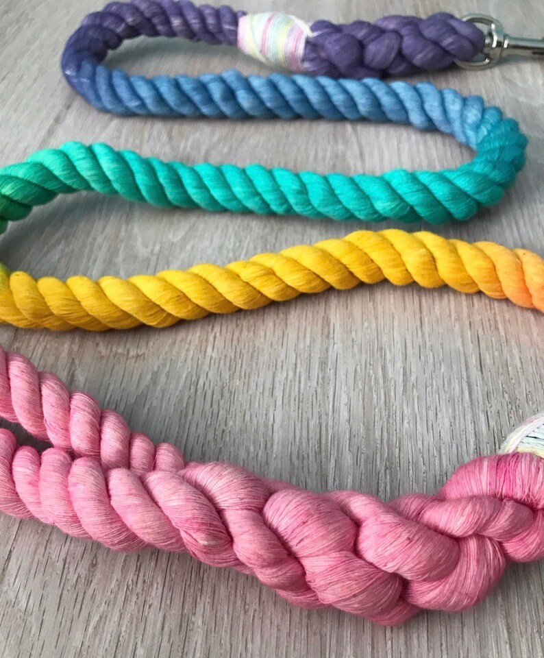 May include: A set of four colorful cotton rope leashes in rainbow colors, including purple, blue, green, yellow, and pink.