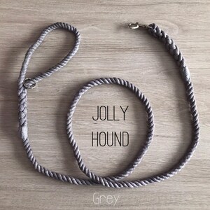 May include: A grey rope dog leash with a silver clip and a metal ring. The leash is coiled and the text "JOLLY HOUND" and "Grey" is visible.