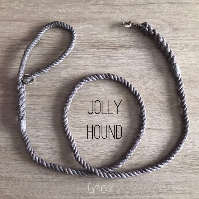 May include: A grey rope dog leash with a silver clip and a metal ring. The leash is coiled and the text "JOLLY HOUND" and "Grey" is visible.