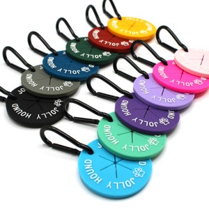 May include: Assortment of ten colourful silicone dog treat pouches with a carabiner clip. Each pouch has the words "Jolly Hound" printed on it.