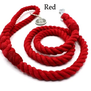 May include: Red cotton rope dog leash with a silver clip and a metal tag that says "Tally Hound".