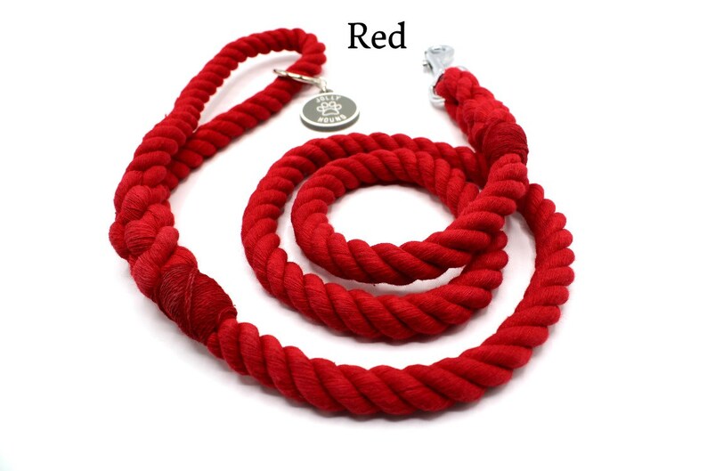 May include: Red cotton rope dog leash with a silver clip and a metal tag that says "Tally Hound".