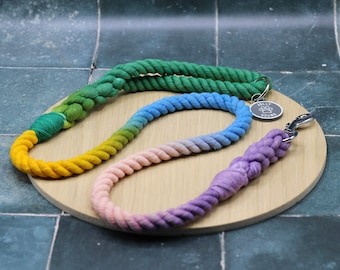 May include: Three colorful dog leashes, one green, one blue and one purple, with a silver tag that says "Jolly Hounds".