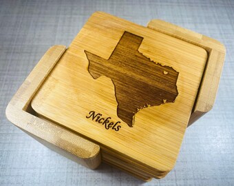 May include: A set of square bamboo coasters with a laser-etched outline of the state of Texas. The word "Nickels" is etched on the coaster. The coasters are stored in a matching bamboo holder.