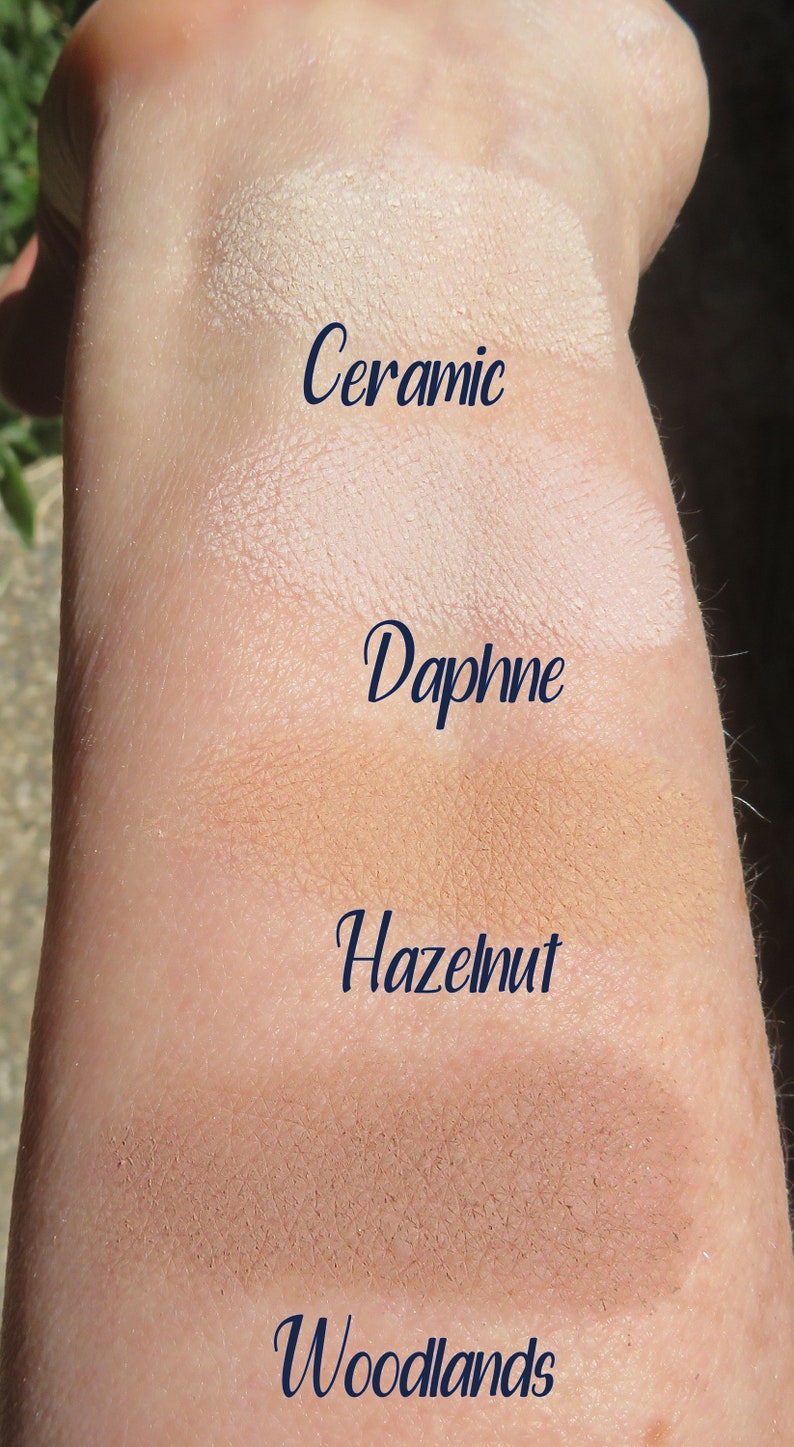 Peut inclure: Des &eacute;chantillons de quatre teintes de fond de teint diff&eacute;rentes sur le bras d'une personne. Les teintes sont &eacute;tiquet&eacute;es "Ceramic", "Daphne", "Hazelnut" et "Woodlands".