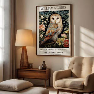 May include: A framed poster with a white owl surrounded by flowers. The poster is titled 'William Morris Cotton Prints Exhibition' and includes the text 'Nearest Station South Kensington' and 'Mar. 23rd to May 18th. Admission Free.'