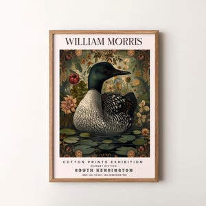 Puede incluir: Un cartel vintage que anuncia una exposición de estampados de algodón de William Morris en el museo de South Kensington en Londres. El cartel presenta una ilustración detallada de un colimbo nadando en un estanque rodeado de flores y follaje.