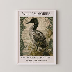 Puede incluir: Un cartel vintage que anuncia una exposición de estampados de algodón de William Morris en la estación de South Kensington en Londres. El cartel presenta un pájaro buceador blanco y negro de pie en una rama con hojas verdes y flores. El cartel tiene un borde de patrón damasco verde y blanco.