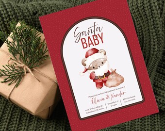 May include: Red baby shower invitation with a Santa Baby theme. The invitation features a watercolor illustration of a bear dressed as Santa Claus. The text reads "Santa Baby" and includes event details.
