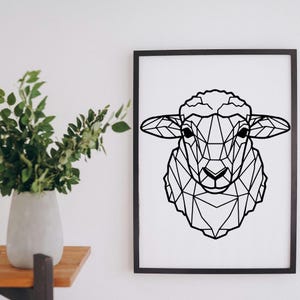 May include: Black framed print featuring a geometric design of a sheep's head. The artwork is a minimalist, modern style, with the sheep's form created from interconnected lines. The print is displayed on a white wall.
