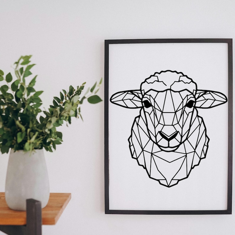 May include: Black framed print featuring a geometric design of a sheep's head. The artwork is a minimalist, modern style, with the sheep's form created from interconnected lines. The print is displayed on a white wall.