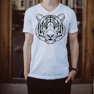 May include: White V-neck t-shirt featuring a geometric black tiger face design. The tiger's face is composed of interconnected lines and shapes, creating a modern, artistic look. The shirt is a casual wear item.