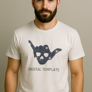 Peut inclure: Un t-shirt de couleur claire avec un motif de crâne bleu foncé en forme de geste de la main. Le texte "DIGITAL TEMPLATE" est imprimé en dessous. Le t-shirt est porté par une personne.