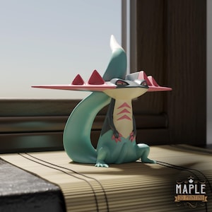 May include: A 3D-printed figurine of a stylized creature with a teal body, a pink and gray head, and a long, curved tail. The creature has a flat, pink structure on its head with red triangular accents. It is posed on a bamboo mat.