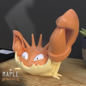 May include: A 3D-printed, orange and cream-colored Krabby figurine. The crab-like creature has large claws, spiky protrusions, and white eyes. The Maple 3D Printing logo is visible in the lower left corner.
