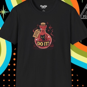 May include: Black t-shirt with a potion bottle graphic containing a black cat and the words "DO IT!". The bottle has a cork and a tag that reads "DON'T OPEN EVIL INSIDE". The shirt has the brand name "Prychic" on the top.