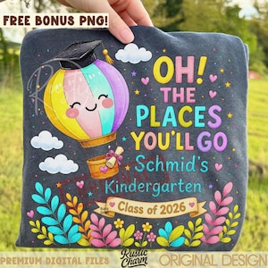 May include: Dark gray sweatshirt with a colorful hot air balloon graphic wearing a graduation cap. Text includes "OH! THE PLACES YOU'LL GO Schmid's Kindergarten Class of 2026". Decorative floral and heart accents surround the design.