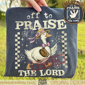 May include: A navy blue sweatshirt featuring a whimsical illustration of a goose wearing a hat and holding a Bible. The text "off to PRAISE THE LORD" is printed above and below the goose. The design includes floral and checkered elements.