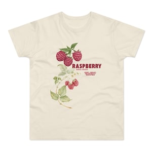 Könnte beinhalten: Ein cremefarbenes T-Shirt mit einer Vintage-Illustration von Himbeeren und dem Text "RASPBERRY, RUBUS IDAEUS, SWEET, VIBRANT, AND NATURALLY IRRESISTIBLE."