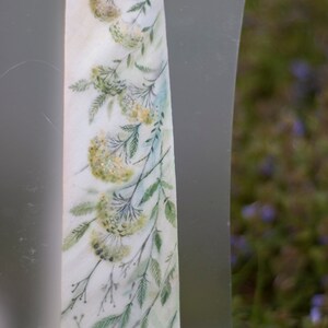 Puede incluir: Una corbata de seda blanca con un dise&ntilde;o de acuarela de hojas verdes y flores amarillas.