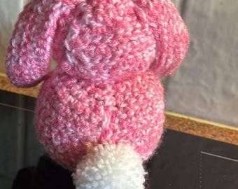 Könnte beinhalten: Ein rosa und weiß gehäkeltes Häschen mit einem weißen Bommel-Schwanz.