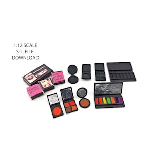 Puede incluir: Un conjunto de paletas de maquillaje en miniatura a escala 1:12, que incluye una paleta de rubor, polvo suelto fijador y paletas de sombras de ojos. Las paletas son negras con una variedad de colores y texturas.