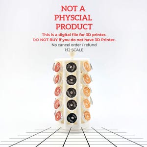 May include: A white, cylindrical coffee pod holder with multiple levels, each holding coffee pods in various colors. The text "NOT A PHYSCIAL PRODUCT" and other text is visible at the top. The image is a digital file for a 3D printer.