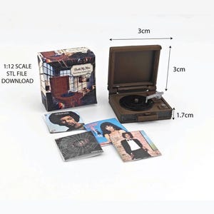 May include: Miniature brown record player, 3cm x 3cm x 1.7cm, with a black record and a selection of album covers. A box with the text "Built My Man" is also present, along with the text "1:12 SCALE STL FILE DOWNLOAD".