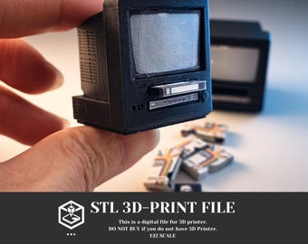 May include: A miniature black 3D-printed television set with a screen and a slot for a small cassette tape. The device features a textured surface and includes several tiny cassette tapes with colorful labels. The text reads STL 3D-PRINT FILE.