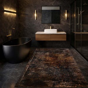 Op de afbeelding: Een moderne badkamer met een zwarte ovale badkuip, een houten wastafel met een witte rechthoekige wastafel en een groot patroon tapijt. De muren zijn donkergrijs met gouden accenten van de verlichting en armaturen. Een glazen douchecabine is zichtbaar.
