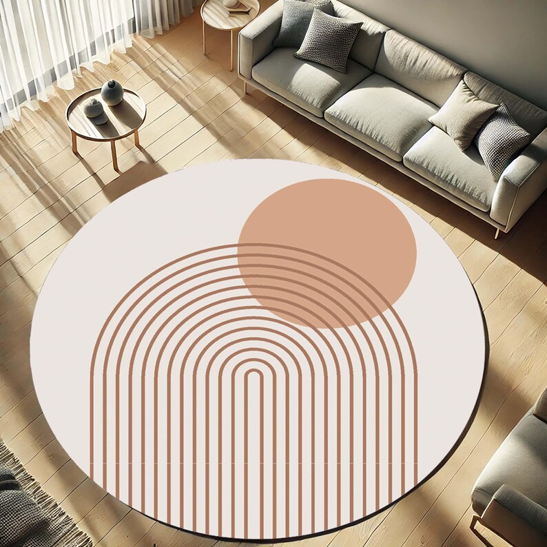 Pu&ograve; includere: Un tappeto rotondo con sfondo color crema e design geometrico. Il design presenta un grande cerchio color pesca e linee arcuate marroni. Il tappeto &egrave; posato su un pavimento in legno, con un divano e tavolini sullo sfondo.