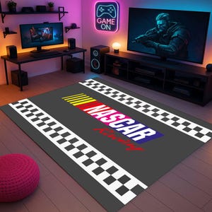 May include: A grey and white chequered rug with the words "NASCAR Racing" in colourful letters. The rug is on a wooden floor in a room with a gaming setup.