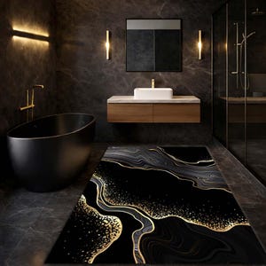 Può includere: Un tappetino da bagno nero e oro con motivo marmorizzato in un bagno moderno. Il tappetino presenta un design fluido con accenti dorati su sfondo nero. Il bagno comprende una vasca da bagno nera, un mobile lavabo in legno e un box doccia in vetro.