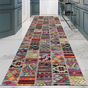 Könnte beinhalten: Ein langer, rechteckiger Teppich mit Patchwork-Design. Der Teppich zeigt eine lebendige Mischung aus Farben, darunter Rot, Orange, Grün, Blau und Lila. Geometrische und Stammesmuster sind sichtbar.