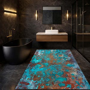 Puede incluir: Alfombra rectangular para baño con diseño abstracto. La alfombra presenta una mezcla de colores turquesa, óxido y blanco, creando una apariencia texturizada y artística. Se encuentra en un baño moderno con bañera negra y paredes gris oscuro.