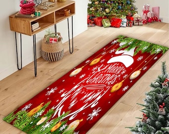 Op de afbeelding: Een rechthoekig rood kersttapijt met de tekst "Merry Christmas" in witte letters. Het tapijt heeft een rendiersilhouet, sneeuwvlokken en decoratieve lampjes. Groene dennentakken en gele accenten sieren de randen.